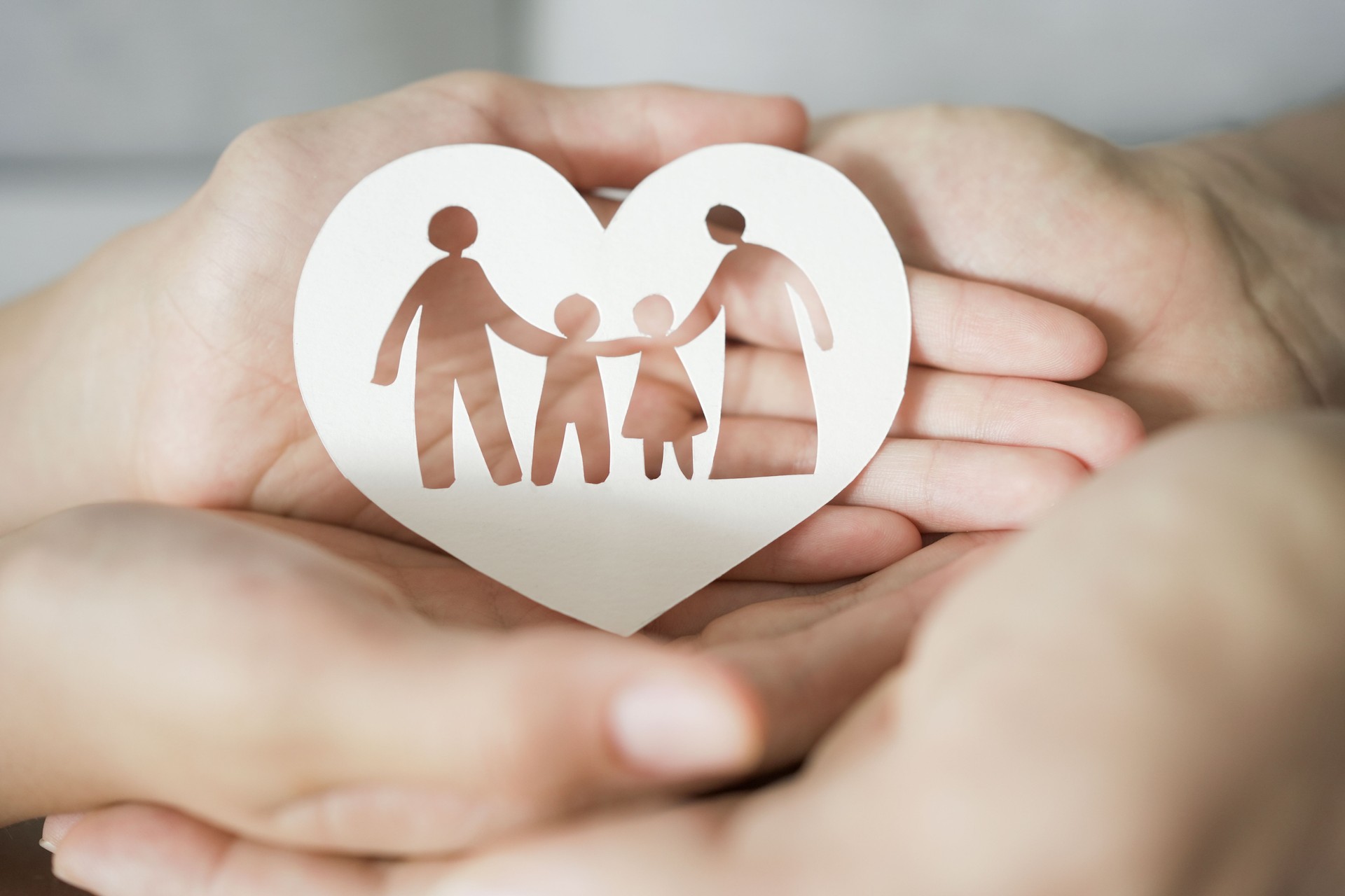 Hands holding paper family cutout, family home,life insurance, adoption foster care, homeless support , mental health, homeschooling education, Autism support, parent day