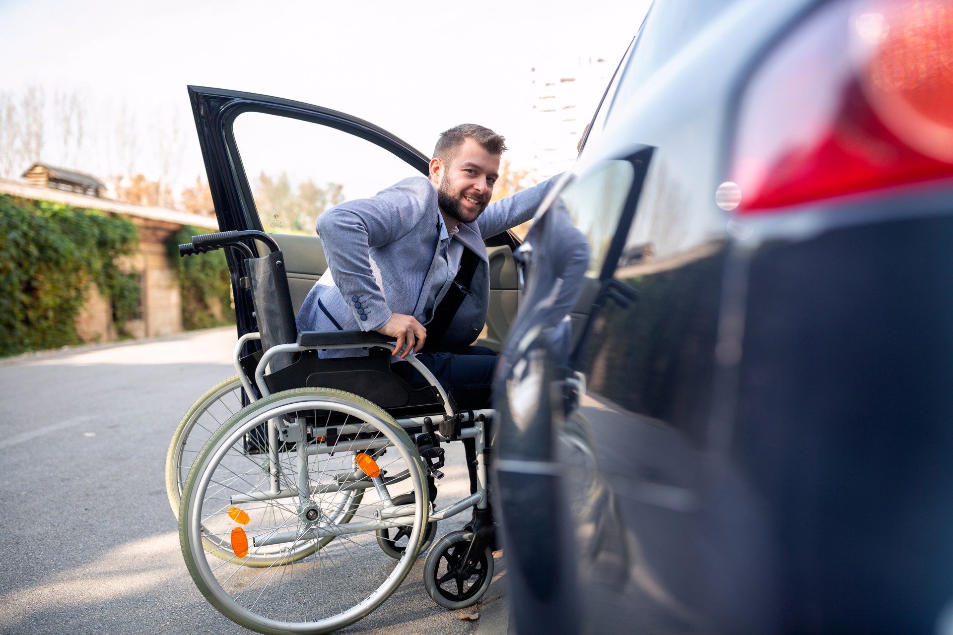 Handicapped man attempting to get in the car